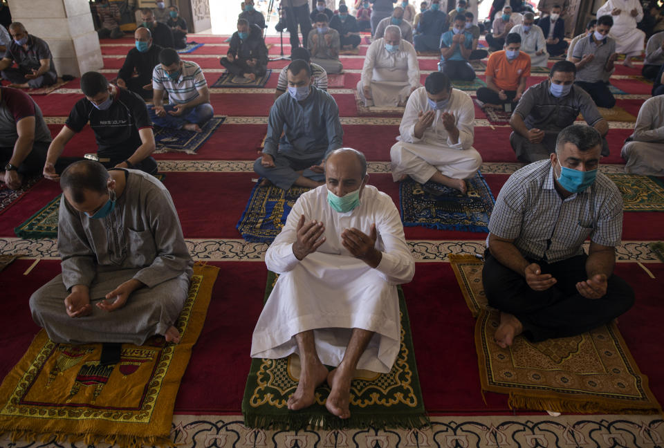 Palestinians wearing face masks attend the last Friday noon Prayer of the holy month of Ramadan, in a mosque in Gaza City, Friday, May. 22, 2020. After nearly two months of closure due to the coronavirus, Gaza's Hamas rulers decided to partially reopen mosques for the Friday noon prayer. (AP Photo/Khalil Hamra)