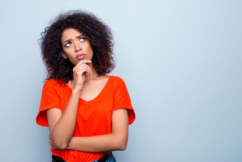 Woman standing with hand on chin contemplating her decision