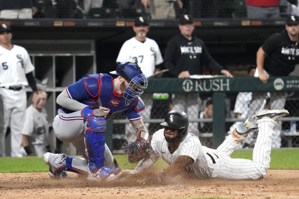 Chicago White Sox's Elvis Andrus, right, scores against Texas Rangers catcher Jonah Heim in the eighth inning of a baseball game in Chicago, Tuesday, June 20, 2023. The White Sox won 7-6.  (AP Photo/Nam Y. Huh)