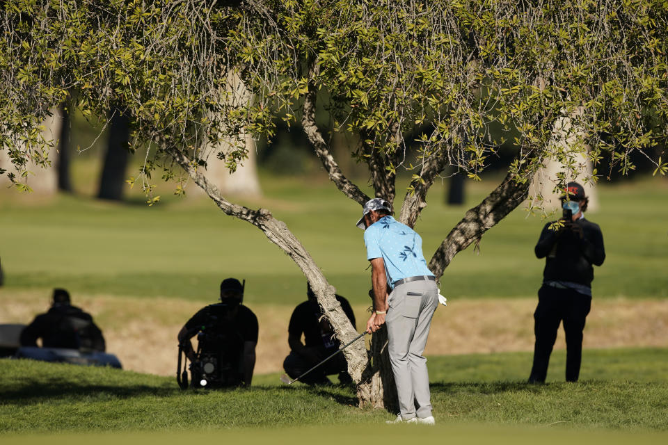 FILE - Max Homa hits his second shot from under a tree on the 10th hole during the first playoff hole against Tony Finau in the final round of the Genesis Invitational golf tournament at Riviera Country Club, Sunday, Feb. 21, 2021, in the Pacific Palisades area of Los Angeles. The shot helped him stay in a playoff he won and was the best gap wedge of the year.(AP Photo/Ryan Kang, File)