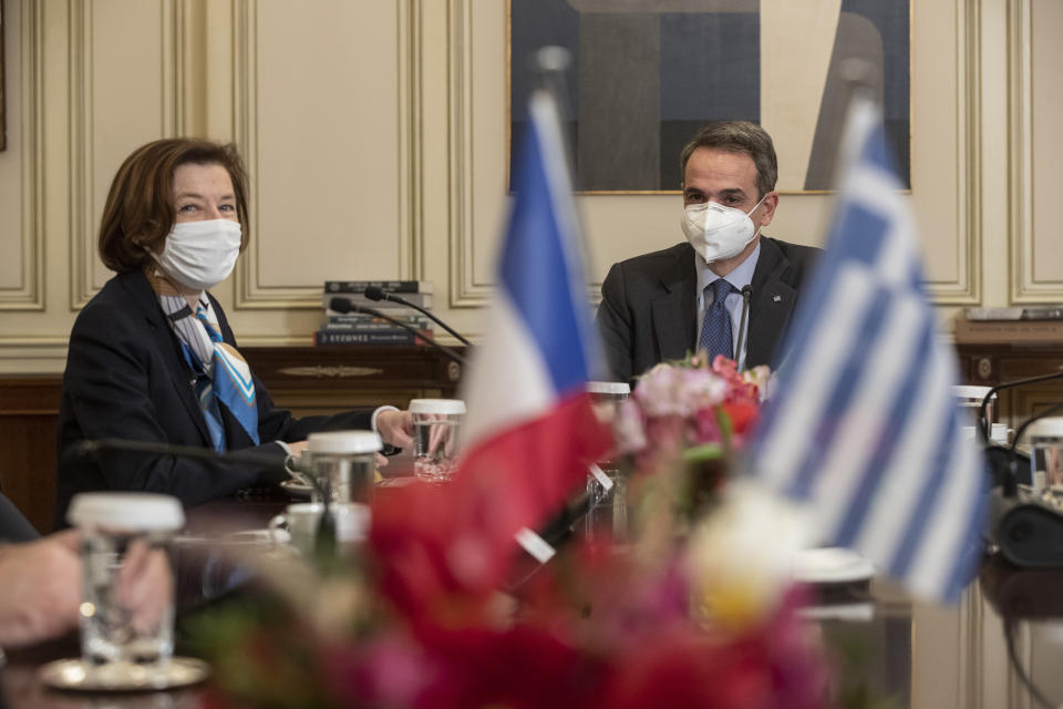 Greek Prime Minister Kyriakos Mitsotakis, right, speaks with French Defense Minister Florence Parly, during their meeting in Athens on Monday Jan. 25, 2021. Greece signed a 2.3 billion euro ($2.8 billion) deal with France Monday to purchase 18 Rafale fighter jets to address tension with neighbor Turkey. (AP Photo/Petros Giannakouris)