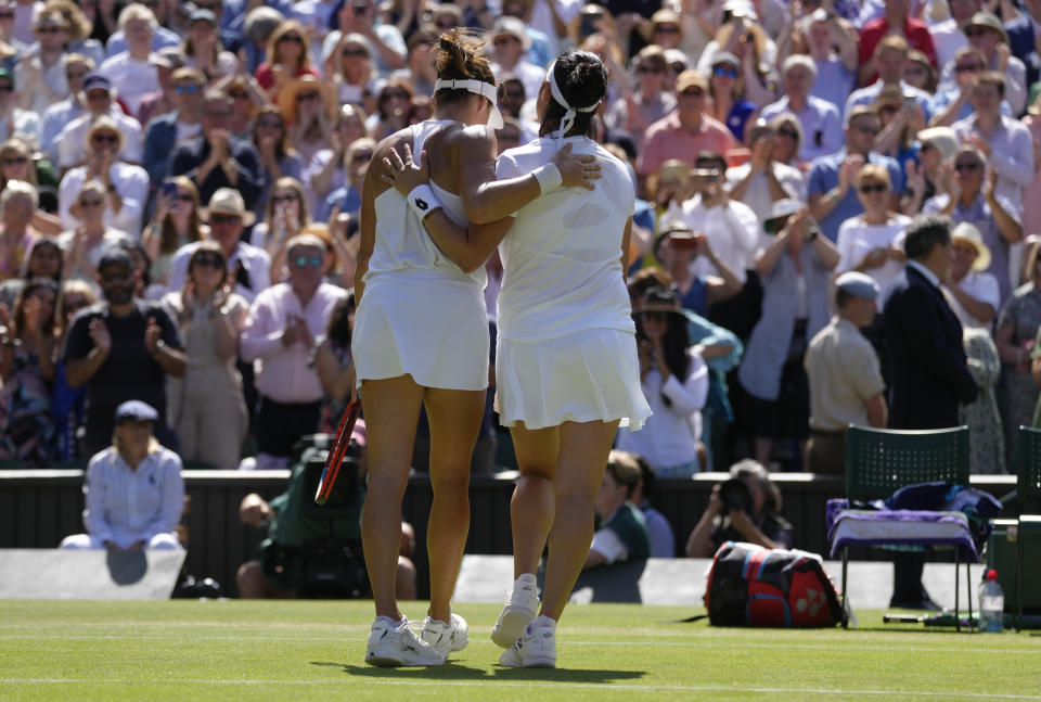 Tunisia's Ons Jabeur, right, embraces Germany's Tatjana Maria after beating her in a women's singles semifinal match on day eleven of the Wimbledon tennis championships in London, Thursday, July 7, 2022. (AP Photo/Kirsty Wigglesworth)