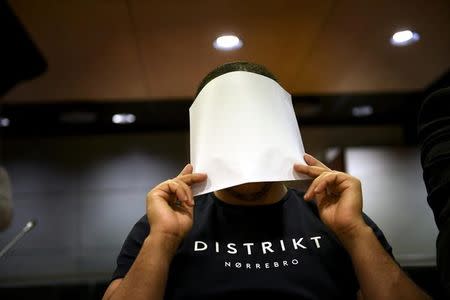 The 24-year-old Moroccan Abdederrazak Essarioul, covers his face during the initial remand hearing of suspects in the stabbing attack in Turku last week, at the Southwest Finland District Court in Turku, Finland, August 22, 2017. Martti Kainulainen via REUTERS