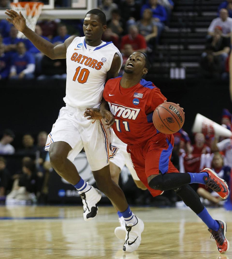 Dayton guard Scoochie Smith (11) moves the ball against Florida forward Dorian Finney-Smith (10) during the first half in a regional final game at the NCAA college basketball tournament, Saturday, March 29, 2014, in Memphis, Tenn. (AP Photo/John Bazemore)