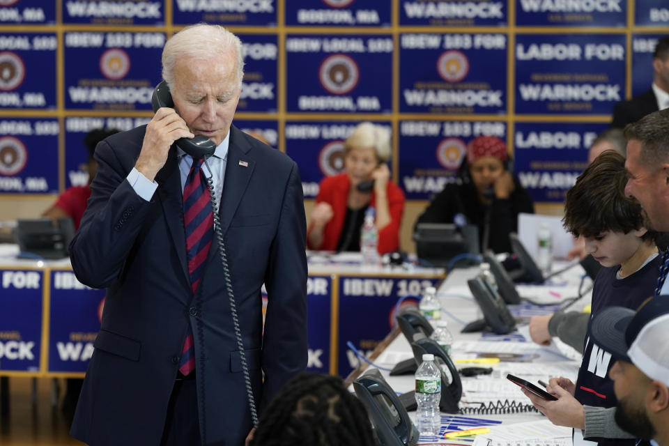 President Joe Biden speaks on the phone while visiting a phone bank at International Brotherhood of Electrical Workers Local 103, Friday, Dec. 2, 2022, in Boston. (AP Photo/Patrick Semansky)