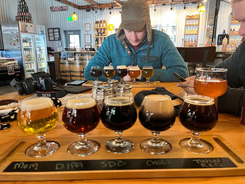 A flight of beer at an Alaska brewery with a person sitting in the background