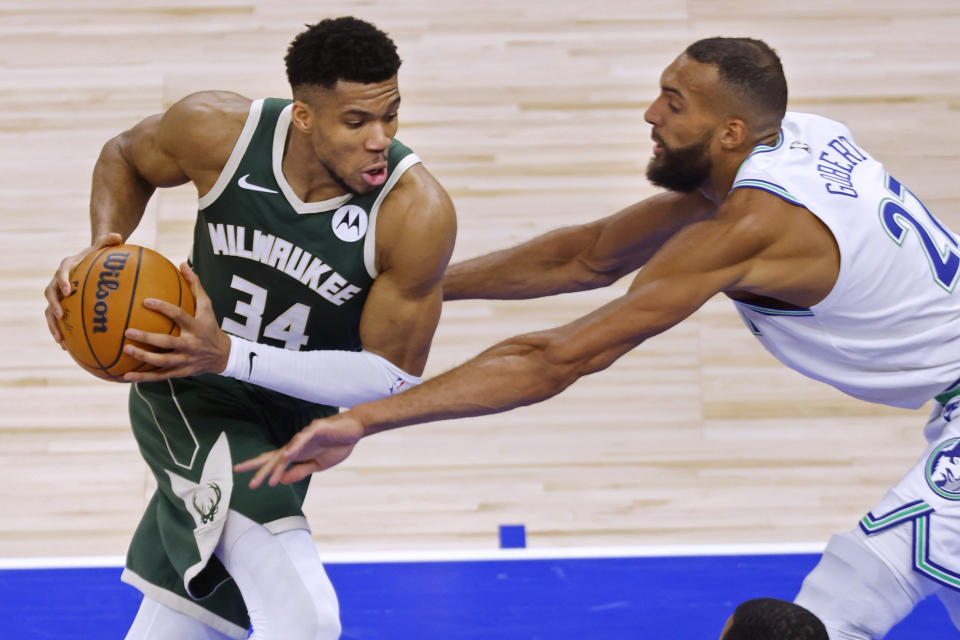 Milwaukee Bucks forward Giannis Antetokounmpo (34) goes to the basket against Minnesota Timberwolves center Rudy Gobert (27) during the second half of an NBA basketball game Friday, Feb. 23, 2024, in Minneapolis. (AP Photo/Bruce Kluckhohn)