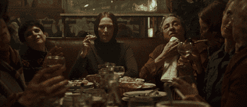 Group gathered around a dinner table in a scene from the film Suspiria