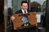 <p>Leader of the Nick Xenophon Team, Australian Senator Nick Xenophon arrives at the Senate entrance holding a novelty doormat depicting US President Donald Trump and reading ‘Australia: Not Your Doormat,’ at Parliament House in Canberra, Australian Capital Territory, Australia, Feb. 7, 2017. (Photo: Mick Tsikas/EPA) </p>