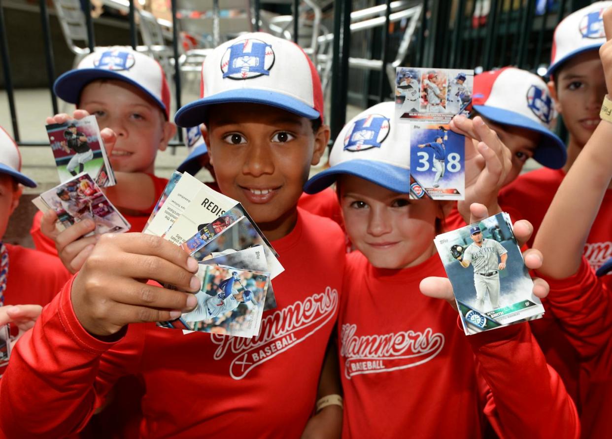 The U.S. sports card industry is an estimated $12 billion market. <a href="https://www.gettyimages.com/detail/news-photo/group-of-young-fans-hold-up-their-topps-baseball-cards-news-photo/830913124?adppopup=true" rel="nofollow noopener" target="_blank" data-ylk="slk:Mark Cunningham/MLB Photos via Getty Images;elm:context_link;itc:0;sec:content-canvas" class="link ">Mark Cunningham/MLB Photos via Getty Images</a>