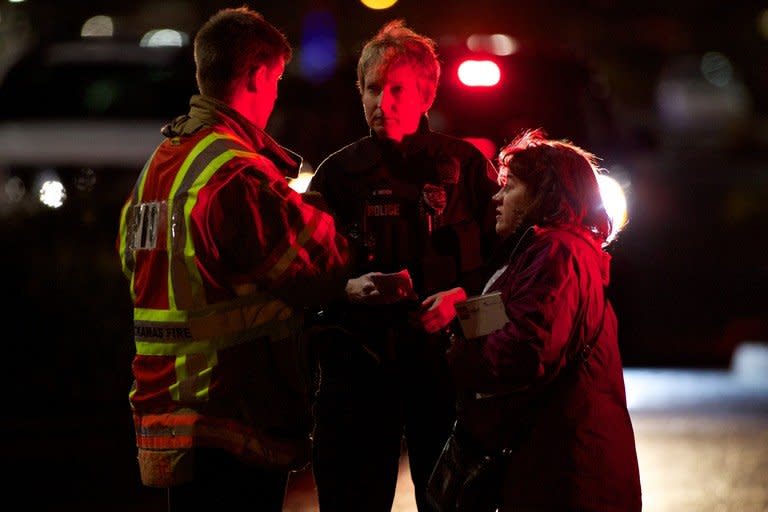 A police officer and firefighter speak to a woman outside the Clackamas Town Center during a shooting on December 11, 2012 in Clackamas, Oregon. At least two people were killed when a masked gunman opened fire at the mall, sparking panic before apparently turning the gun on himself, police said