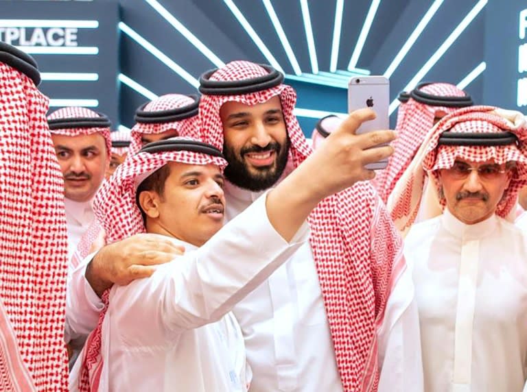 A handout picture provided by the Saudi Royal Palace on October 23, 2018 shows Crown Prince Mohammed bin Salman (centre) posing for a selfie near Saudi billionaire Prince Al-Walid bin Talal (right) during the Future Investment Initiative conference