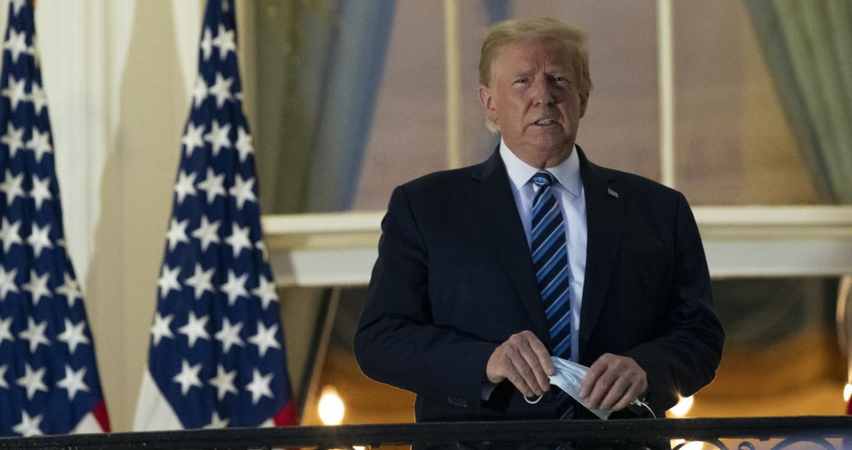 <span class="caption">U.S. President Donald Trump removes his mask as he stands on the Blue Room Balcony upon returning to the White House Monday, Oct. 5, 2020, in Washington, after spending time in hospital with a COVID-19 infection.</span> <span class="attribution"><span class="source"> (AP Photo/Alex Brandon)</span></span>