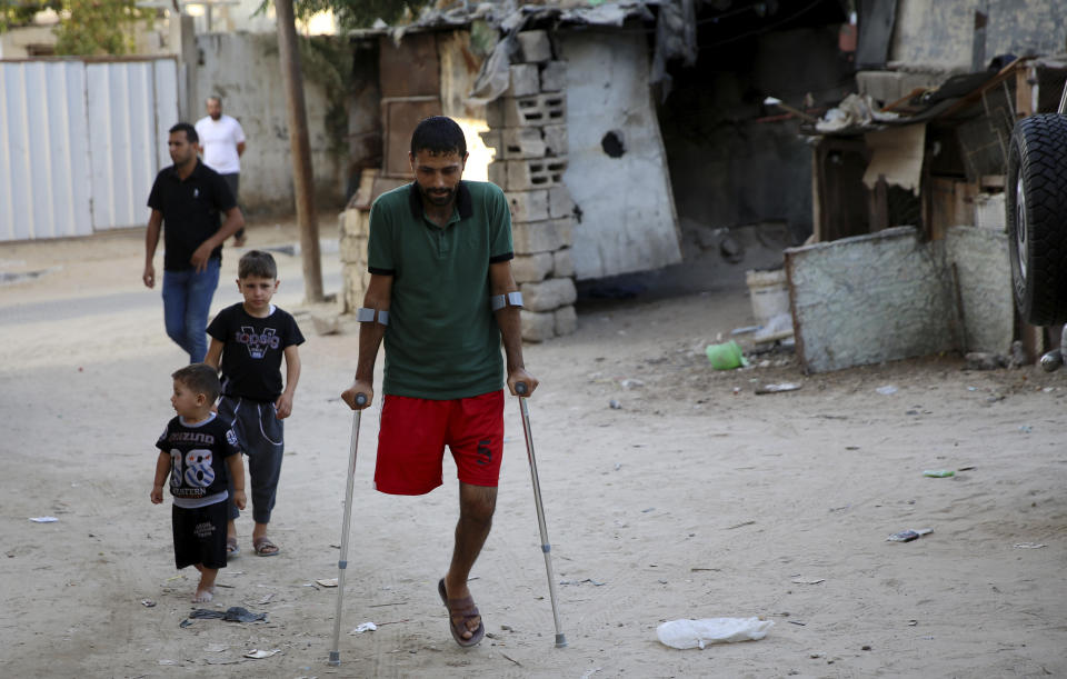 In this Wednesday, Oct. 2, 2019 photo, a Palestinian amputee Ziad al-Madani, who lost his leg when he was shot by Israeli troops during a protest on the border, walks on the main street of Khan Younis, Gaza Strip. Gaza’s Hamas rulers are facing a rare and growing chorus of criticism, with little to show after 18 months of mass protests along the Israeli border organized by the Palestinian militant group. Gazans are increasingly questioning the high number of casualties and lack of success in lifting the Israeli blockade. Against this backdrop, activist Ahmed Abu Artima has launched his own peaceful version of the protest. (AP Photo/Adel Hana)