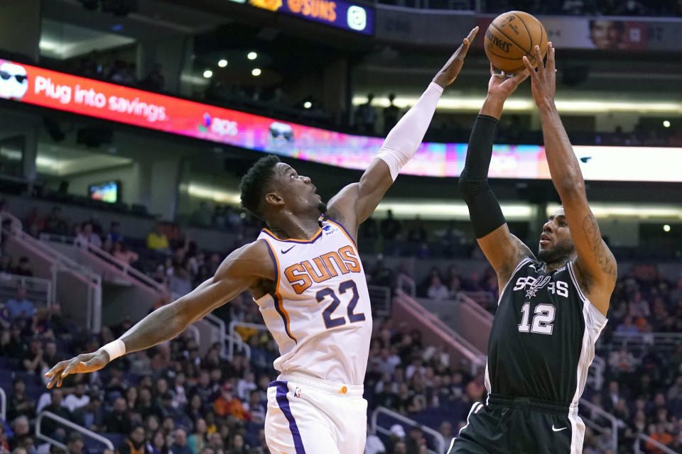 San Antonio Spurs center LaMarcus Aldridge (12) shoots over Phoenix Suns center Deandre Ayton during the first half of an NBA basketball game Monday, Jan. 20, 2020, in Phoenix. (AP Photo/Rick Scuteri)