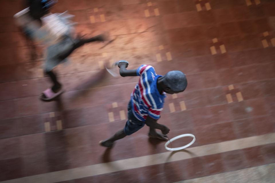 Un niño juega con un aro en el Teatro Nacional donde se refugian familias desplazadas por la violencia de las bandas, en Puerto Príncipe, Haití, el 9 de mayo de 2024. (AP Foto/Ramón Espinosa)