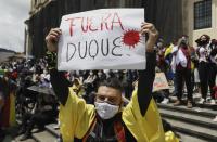 Un manifestante sostiene una pancarta con un mensaje dirigido al presidente de Colombia, Iván Duque, durante una protesta en Bogotá, Colombia, el miércoles 12 de mayo de 2021. (AP Foto/Fernando Vergara)