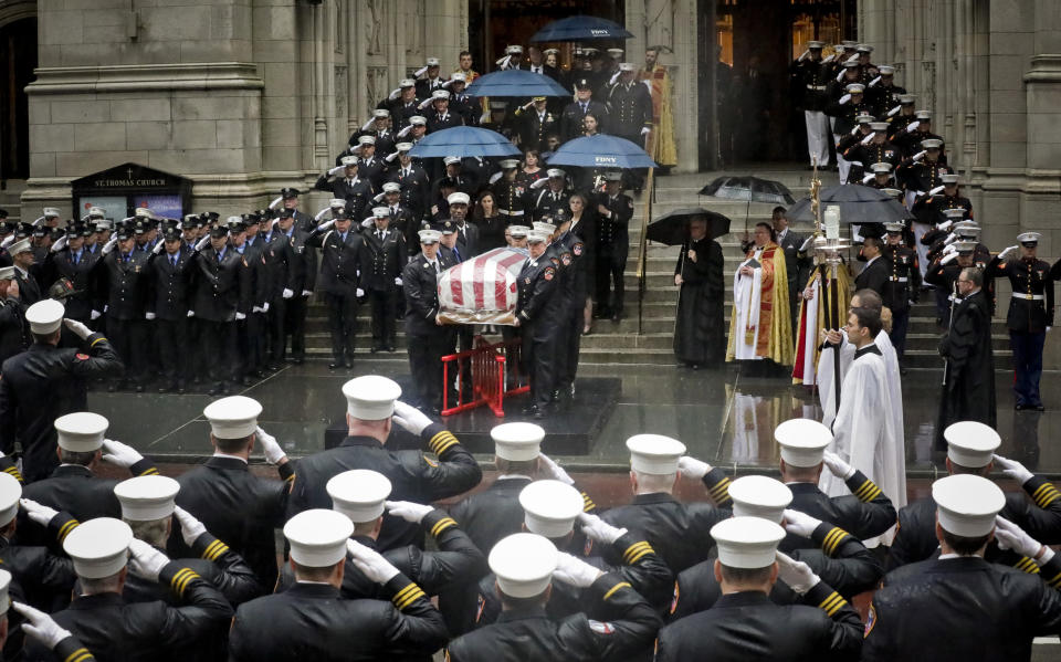 Fire and military officials salute the casket of U.S. Marine Corps Staff Sergeant and FDNY Firefighter Christopher Slutman, as it leaves St. Thomas Episcopal Church, Friday April 26, 2019, in New York. The father of three died April 8 near Bagram Airfield U.S military base in Afghanistan. (AP Photo/Bebeto Matthews)