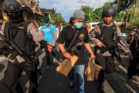 Anti-terrorism policemen carry an envelope after a raid at the house of suspect Nur Rohman at Sukoharjo district near Solo, Indonesia, July 19, 2016. Antara Foto/Maulana Surya/via REUTERS/Files