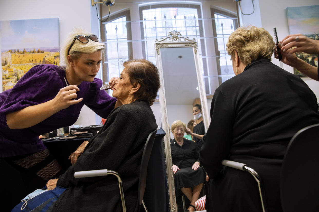 Holocaust survivors get their make-up and hair done during a special beauty pageant honoring Holocaust survivors in Jerusalem, Tuesday, Nov. 16, 2021. Ten contestants participated in the "Miss Holocaust Survivor" pageant, which was held for the first time since 2019 after being suspended due to the coronavirus pandemic. (AP Photo/Oded Balilty)