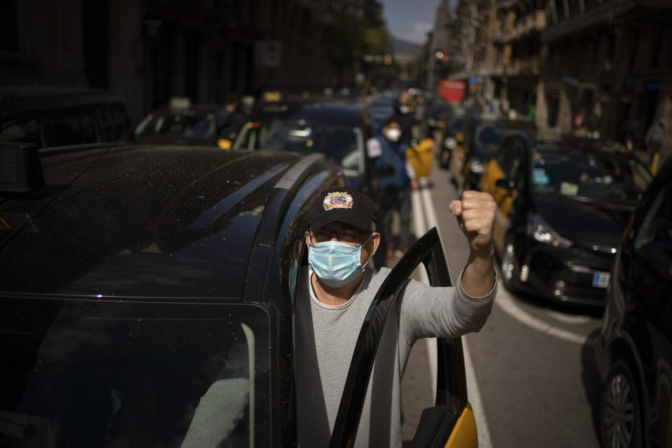 Taxi cabs move slowly blocking the traffic along one of the avenues in Barcelona downtown, Spain, Thursday, March 18, 2021. Hundreds of yellow-and-black cabs disrupted Barcelona's road traffic on Thursday to protest against the return of the ride-hailing giant Uber to the northeastern city after a 2-year hiatus. (AP Photo/Emilio Morenatti)