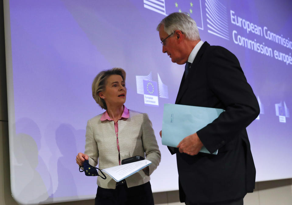 European Commission's Head of Task Force for Relations with the United Kingdom Michel Barnier, right, speaks with European Commission President Ursula von der Leyen after addressing a media conference on Brexit negotiations at EU headquarters in Brussels, Thursday, Dec. 24, 2020. (AP Photo/Francisco Seco, Pool)