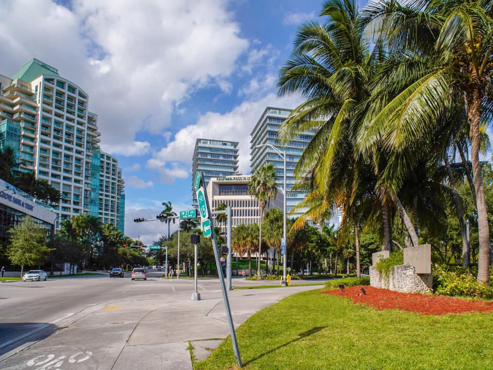 A scene in Coconut Grove with buildings on the left and palm trees on the right