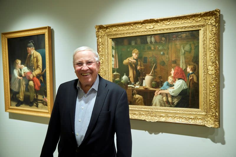 Swiss billionaire and politician Christoph Blocher poses next to Albert Anker paintings "Vieillard et 2 enfant" and "La Mege II" after a guided visit for the media of his collection at the Fondation Pierre Gianadda in Martigny