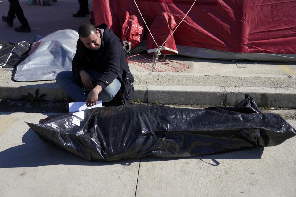 A man cries over the body of earthquake victim outside a hospital in Antakya, southeastern Turkey, Thursday, Feb. 9, 2023. Thousands who lost their homes in a catastrophic earthquake huddled around campfires and clamored for food and water in the bitter cold, three days after the temblor and series of aftershocks hit Turkey and Syria. (AP Photo/Khalil Hamra)