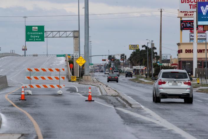 Cars slowly drive on the South Padre Island Drive feeder road after the highway was closed do to ice after a freezing rain and below freezing temperatures on Monday, Feb. 15, 2021.