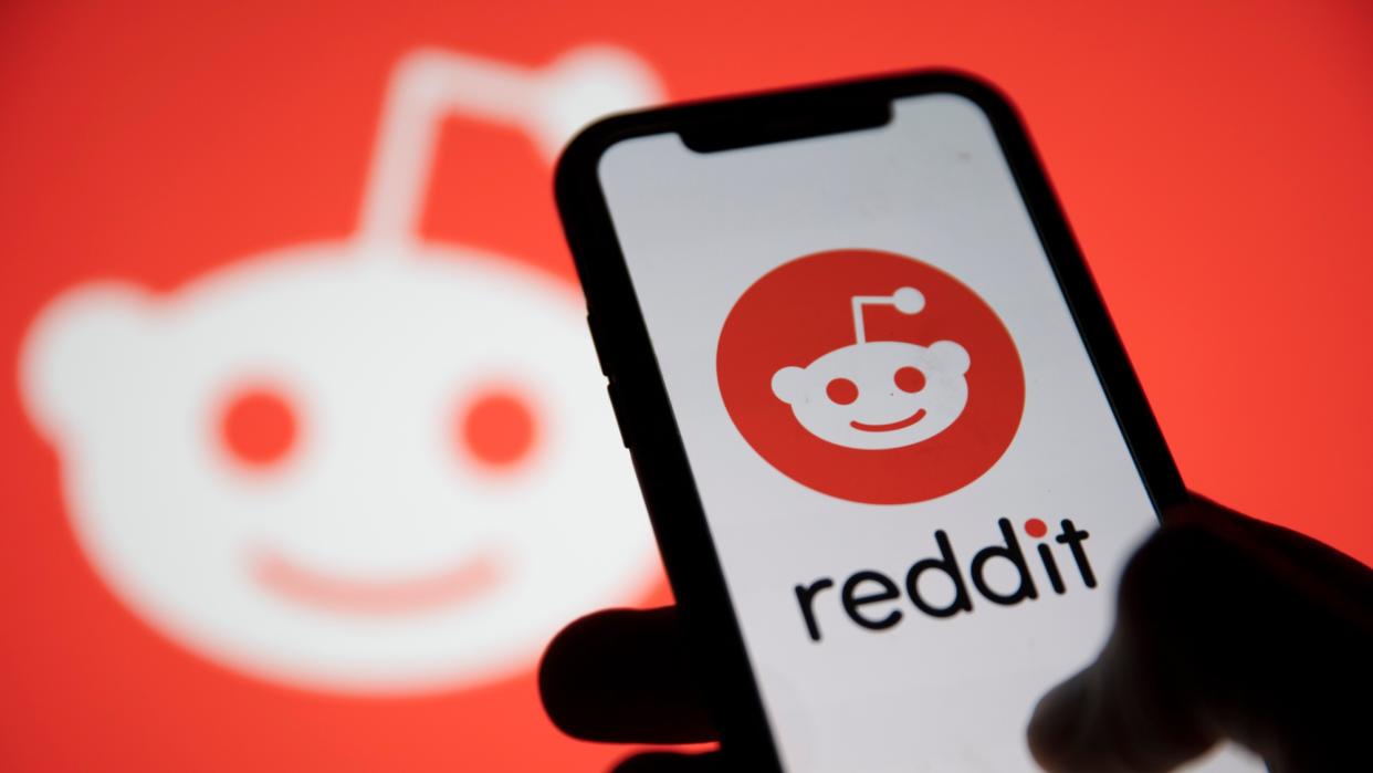  Reddit logo and Reddit logo on phone. 