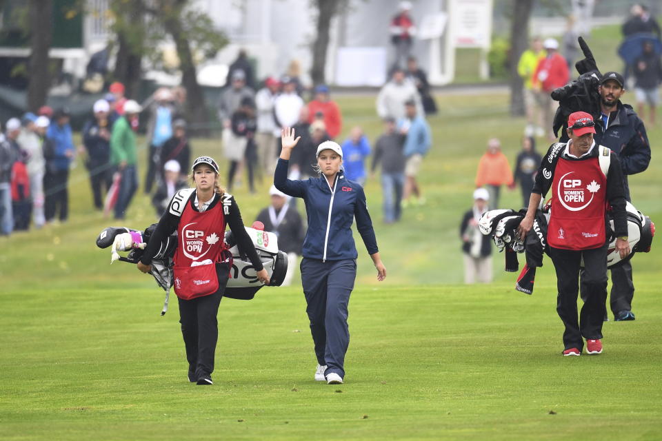 Canada's Brooke Henderson waves to the crowd as she arrives on 18th green during the Women's Canadian Open golf tournament in Regina, Saskatchewan, Sunday Aug. 26, 2018. (Jonathan Hayward/The Canadian Press via AP)