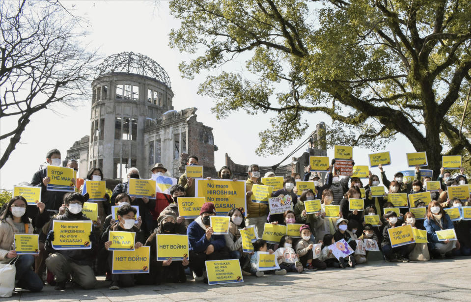 FILE - People show posters that read, "Stop the war, No more Hiroshima, No more Nagasaki, No nukes, No war," during a protest against Russia's invasion of Ukraine, as they gather at Hiroshima Peace Memorial Park in Hiroshima, western Japan, on Feb. 26, 2022. By ending 77 years of almost uninterrupted peace in Europe, war in Ukraine war has joined the dawn of the nuclear age and the birth of manned spaceflight as a watershed in history. After nearly a half-year of fighting, tens of thousands of dead and wounded on both sides, massive disruptions to supplies of energy, food and financial stability, the world is no longer as it was.(Eriko Noguchi/Kyodo News via AP)