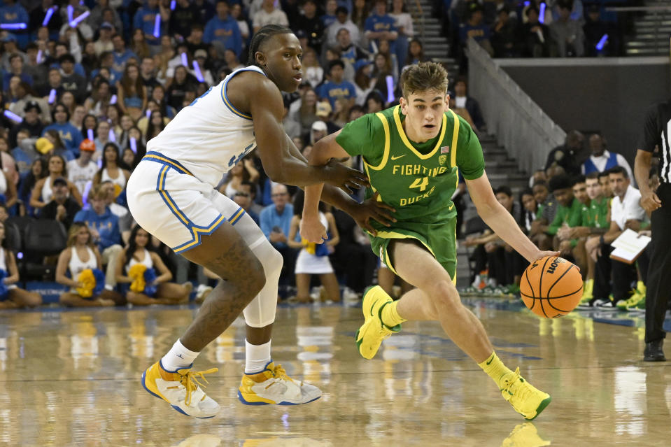 Oregon guard Brennan Rigsby, right, drives past UCLA guard David Singleton during the first half an NCAA college basketball game Sunday, Dec. 4, 2022, in Los Angeles. (AP Photo/John McCoy)