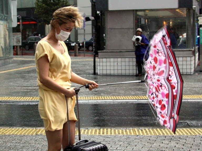 A pedestrian walks against strong wind and rain brought by Typhoon Man-yi in Tokyo, on September 16, 2013