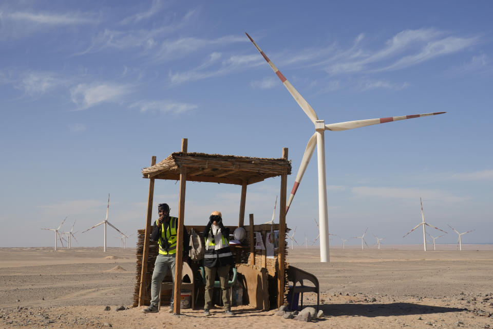 FILE - Bird watchers Omima Sayed, right, and Amr Abdel Hady look out at the the sky while at Lekela wind power station, near the Red Sea city of Ras Ghareb, Egypt, Oct. 12, 2022. The wind power industry on Monday, March 27, projected growth to rapidly accelerate this year, with incentives and policy changes in key nations helping to overcome factors that led to a slowdown in 2022. (AP Photo/Amr Nabil, File)