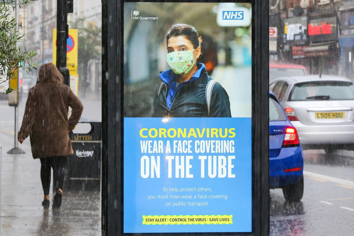 A woman walks past a face mask awareness billboard on a coronavirus public information campaign by Transport for London. (Photo by Dinendra Haria / SOPA Images/Sipa USA)