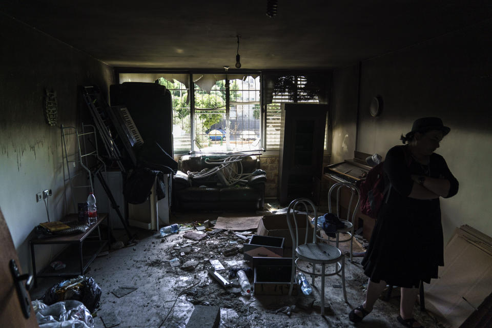 Ayelet-Chen Wadler, a member of the Torah Nucleus community, walks through the torched apartment of a Jewish family after recent clashes between Arabs and Jews in the mixed Arab-Jewish town of Lod, central Israel, Wednesday, May 26, 2021. During the unrest, Arab attackers targeted property belonging to the religious nationalist community. In response, armed West Bank settlers and other ultranationalists mobilized to Lod, fanning the flames. (AP Photo/David Goldman)