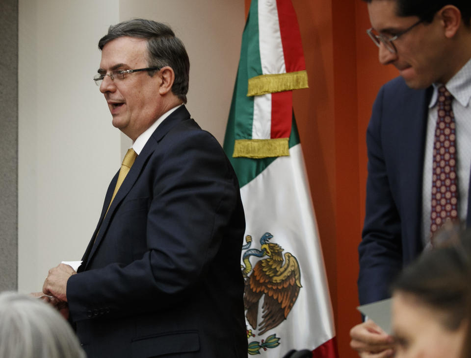 Marcelo Ebrard, Mexico's Secretary of Foreign Affairs, walks past the Mexican flag as he leaves a news conference at the Embassy of Mexico, Wednesday June 5, 2019, in Washington. (AP Photo/Jacquelyn Martin)