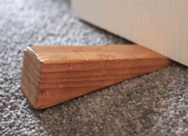 wooden doorstop under door