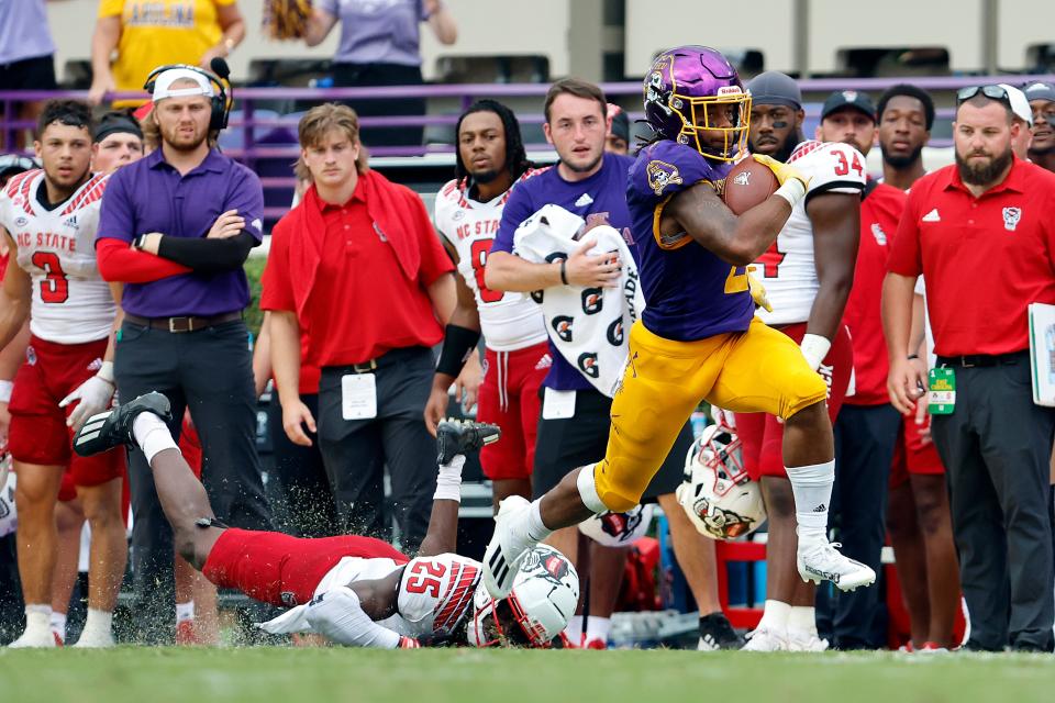 East Carolina's Keaton Mitchell (2) breaks the tackle of North Carolina State's Shyheim Battle (25) during the second half of an NCAA college football game in Greenville, N.C., Saturday, Sept. 3, 2022. (AP Photo/Karl B DeBlaker)