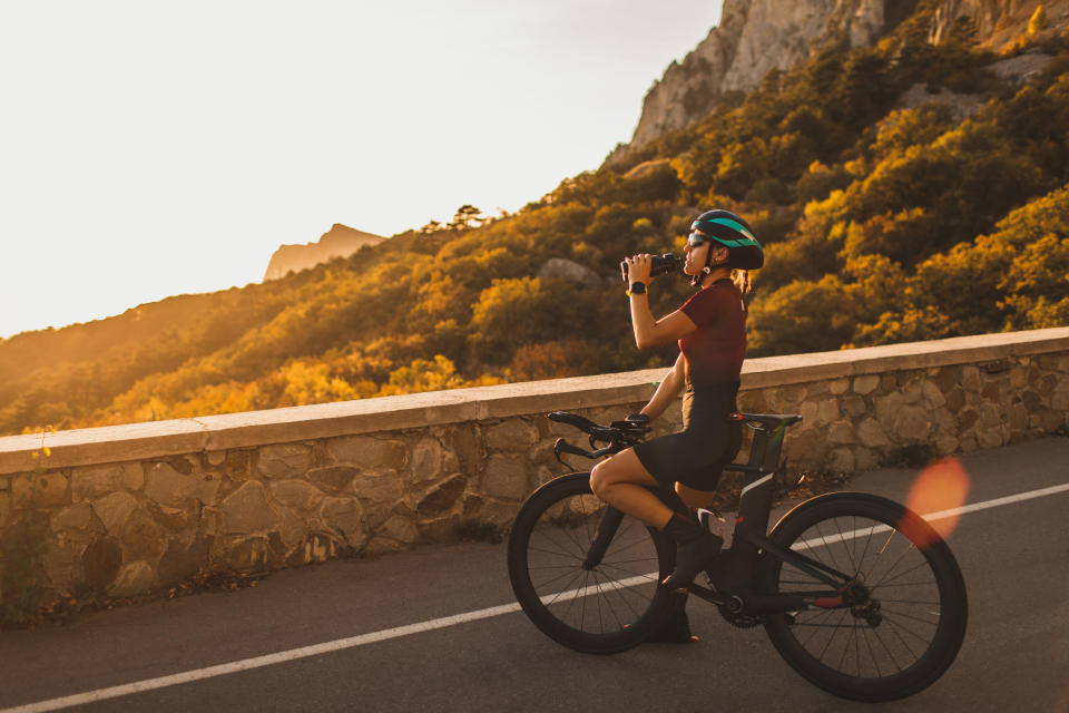 A person riding a bike overlooking the sunset