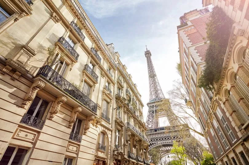 Looking up at The Eiffel Tower through Paris housing, Paris, France