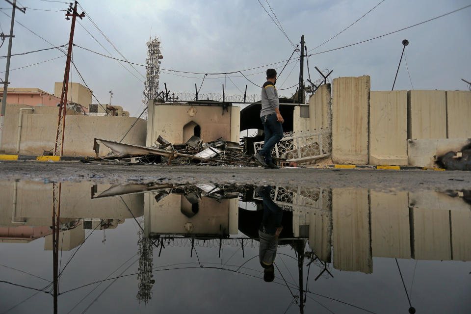 A man passes walks past the burned Iranian consulate in Najaf, Iraq, Thursday, Nov. 28, 2019. An Iraqi police official says anti-government protesters burned down the Iranian consulate in southern Iraq late Wednesday. Protesters torched the Iranian consulate building in the holy city of Najaf, the seat of the country's Shiite religious authority. Iranian staff working in the consulate escaped through the back door and were not harmed. (AP Photo/Anmar Khalil)