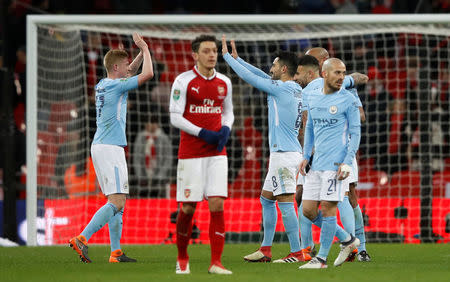 Soccer Football - Carabao Cup Final - Arsenal vs Manchester City - Wembley Stadium, London, Britain - February 25, 2018 Manchester City's Kevin De Bruyne celebrates with Ilkay Gundogan after the match as Arsenal's Mesut Ozil looks dejected Action Images via Reuters/Carl Recine