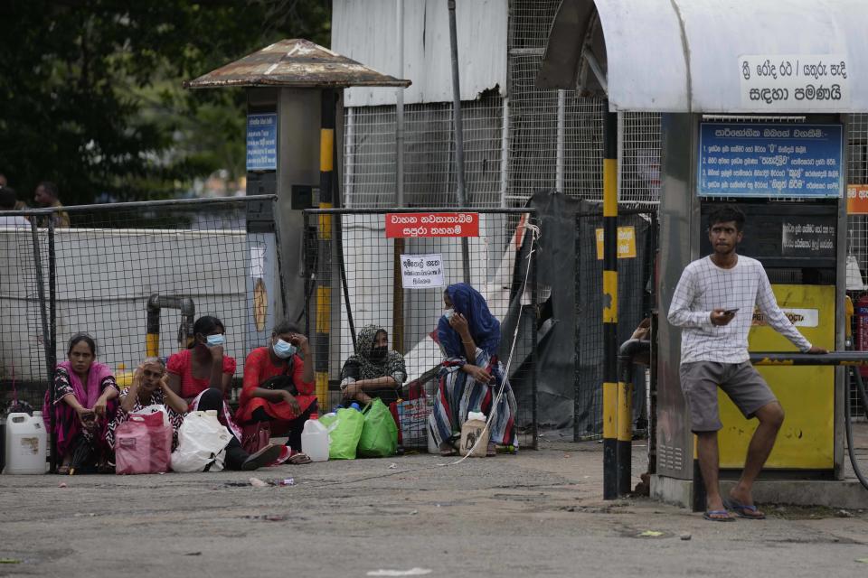 People wait in a fuel station to buy kerosene oil for cooking in Colombo, Sri Lanka, Wednesday, May 18, 2022. Sri Lanka is near bankruptcy having announced that it is suspending upto $ 7 billion foreign loans due to be repaid this year because of a foreign currency crisis. It has led to limited imports with no gasoline in filling stations. Other fuel, cooking gas, medicine and foods are in short supply forcing people to stay in long lines to buy the limited stocks. (AP Photo/Eranga Jayawardena)