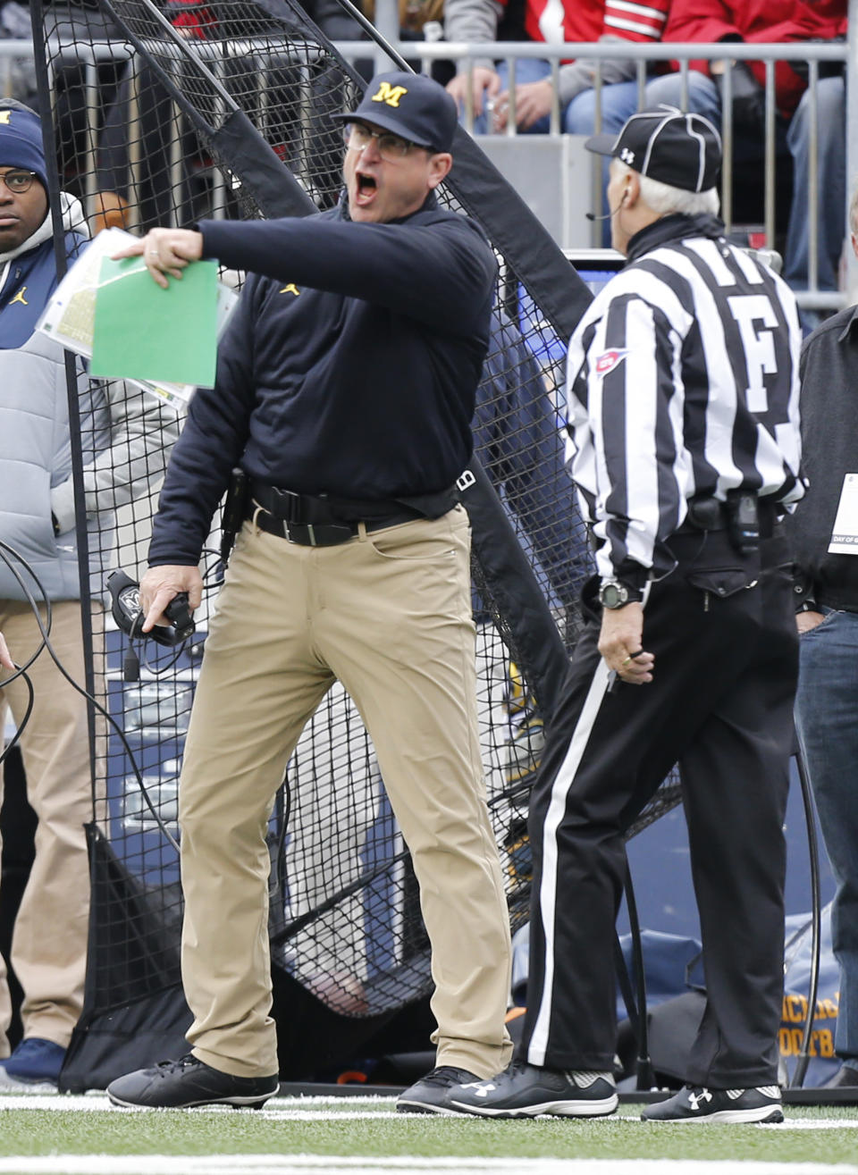 FILE - Michigan head coach Jim Harbaugh, left, yells at the field judge during the first half of an NCAA college football game against Ohio State, Saturday, Nov. 26, 2016, in Columbus, Ohio. Harbaugh said he was “bitterly disappointed with the officiating” after the 30-27 loss.(AP Photo/Jay LaPrete)