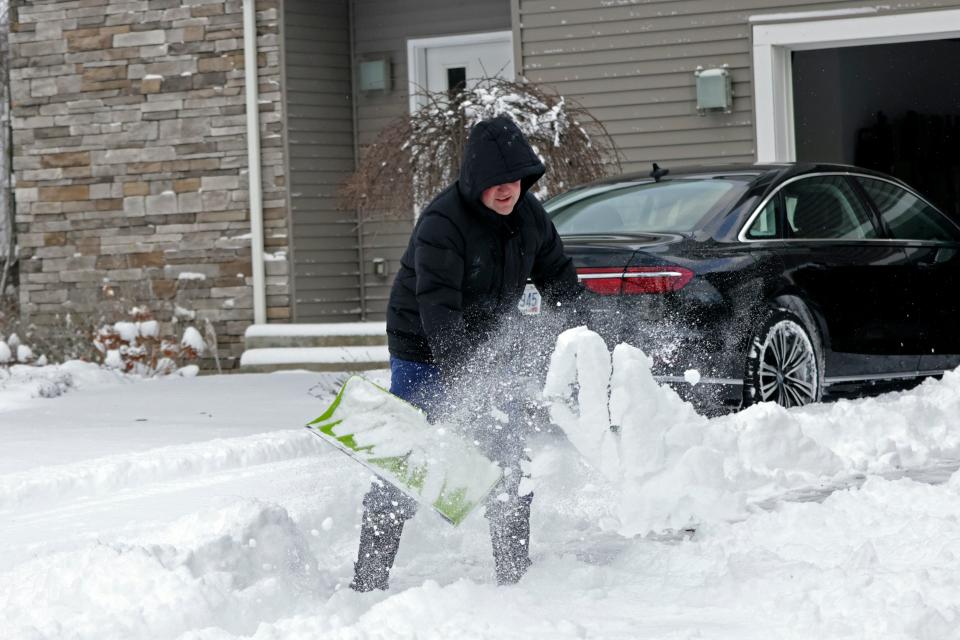 A man clears his driveway in Beachwood, Ohio, after heavy lake-effect snowfall arrived, on Nov. 28. More snow is forecast for portions of the central and eastern U.S. this weekend.