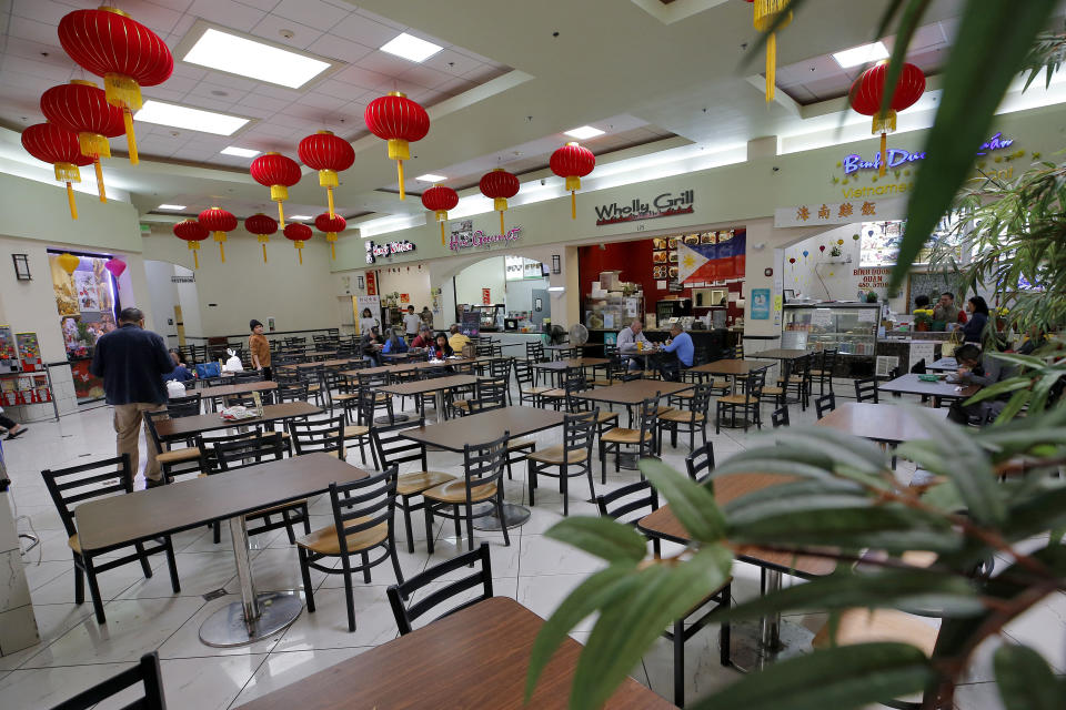 In this Feb. 13, 2020, photo, a sparse lunchtime crowd eats in the food court at Mekong Plaza in the Asian district, in Mesa, Ariz. The Asian district is trying to gain a cultural foothold in the community that previously had little Asian presence but the coronavirus outbreak in China has been impacting business in Mesa and throughout the U.S. (AP Photo/Matt York)