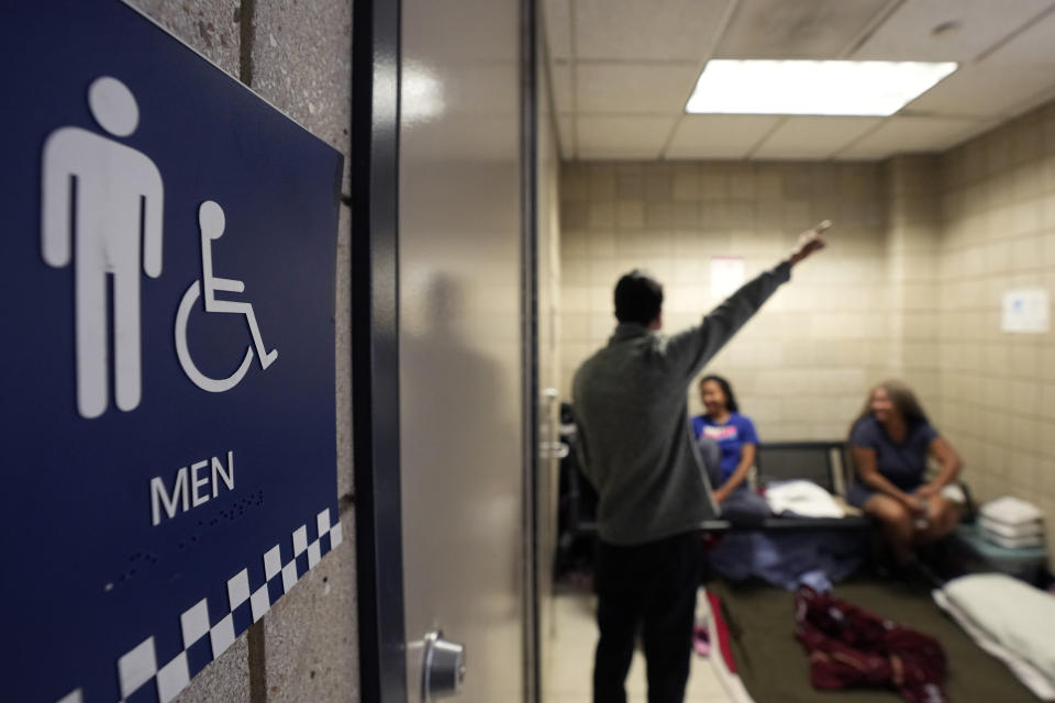 Migrants from Venezuela take shelter in the Chicago Police Department's 16th District station on Monday, May 1, 2023. Chicago has seen the number of new arrivals grow tenfold in recent days. Shelter space is scarce and migrants awaiting a bed are sleeping on floors in police stations and airports. (AP Photo/Charles Rex Arbogast)